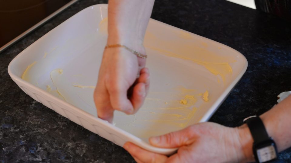 Zapékací mísu vymažeme máslem a vysypeme moukou