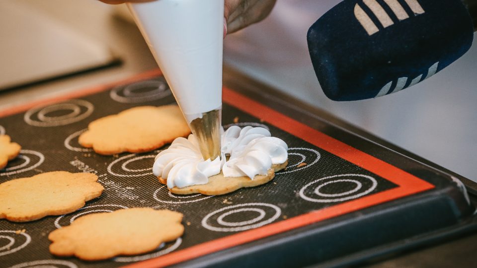 Upečené těsto ve tvaru kytiček zdobíme ochuceným sněhem zvaným meringue
