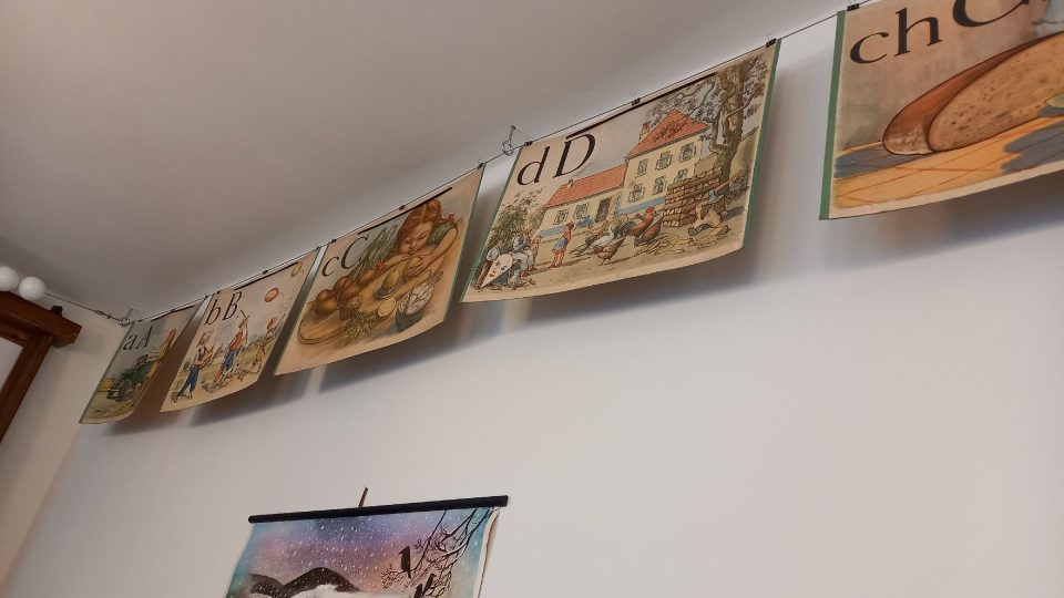 Na stěnách visí staré mapy či naučné obrazové kartonové cedule