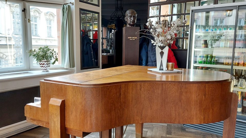 Klavír navržený Gočárem dotváří atmosféru první republiky, vzadu Gočárova busta