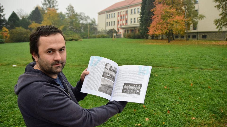 Ondřej Šalek ukazuje fotky v knize 70 let města Kopřivnice. Vlevo dole původní snímek Základní školy Pionýrská, nyní Emila Zátopka (v pozadí)