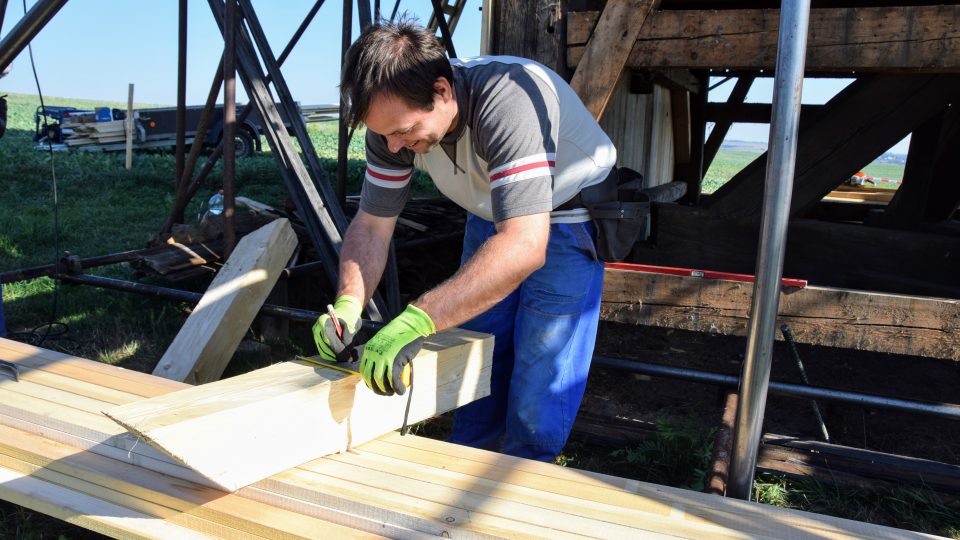 Tesař Martin Hromada rozměřuje dřevěnou náhradu původního trámu