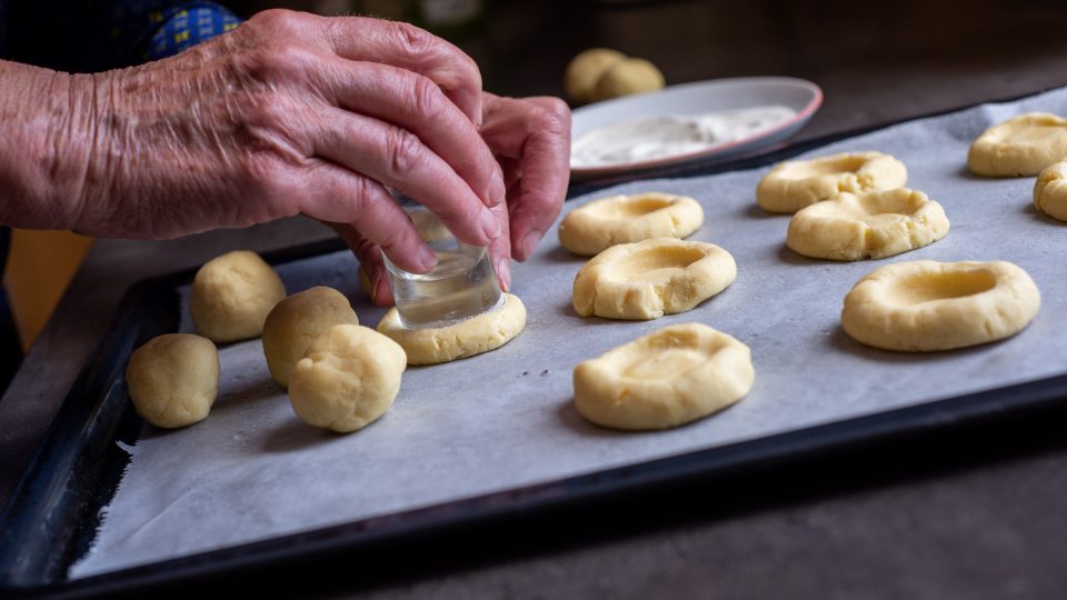 Z těsta tvarujeme kuličky a do nich pomocí skleničky děláme důlky