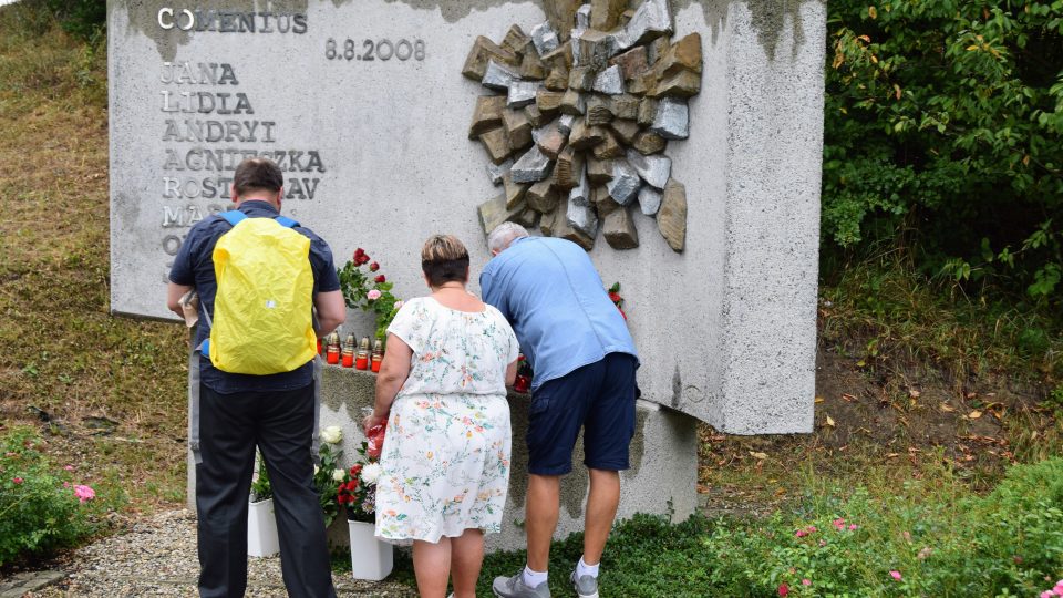 Lidé zapalují svíčky a pokládají květiny k pomníku obětem nehody