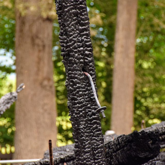 Ohořelý trám s žárem pokřiveným šroubem na troskách kostela v Gutech | foto: Michal Polášek