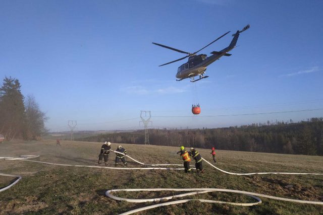 Hasičům při likvidaci požáru pomáhal policejní vrtulník v podvěsu s bambi vakem na vodu | foto: Petr Kůdela,  HZS Moravskoslezského kraje