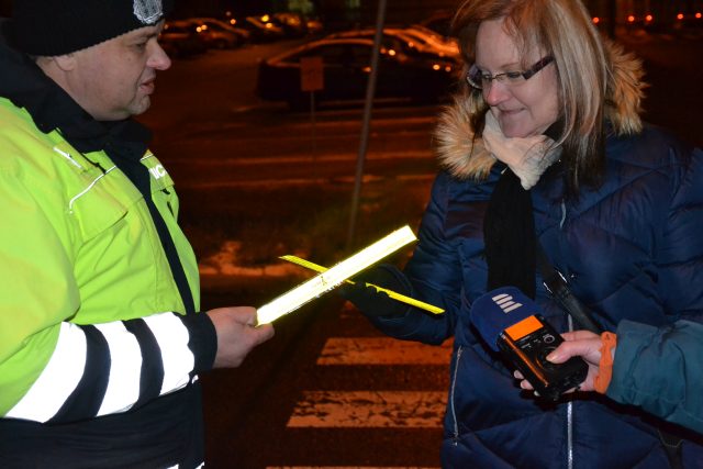 Dopravní policisté rozdávají reflexní pásky. Chtějí,  aby byli chodci dobře vidět | foto: Jan Pechout