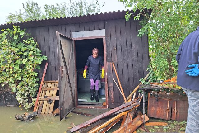 Manželé Tilečkovi odklízejí poničený majetek po povodních ze své zahrady | foto: Andrea Brtníková,  Český rozhlas