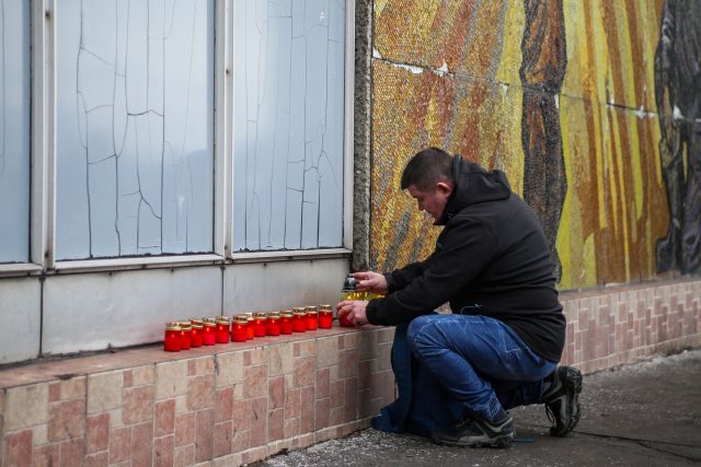 Lidé před budovou dolu ČSM zapalují svíčky | foto: Vladimír Pryček,  ČTK